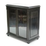 A Victorian ebonised & brass-inlaid display cabinet fitted two adjustable shelves enclosed by pair