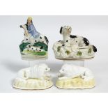 A pair of early 19th century Staffordshire porcelain models of recumbent poodles on shaped oval