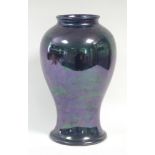 A Moorcroft pottery baluster vase with purple lustre glaze, 12½” high; impressed marks to base: “