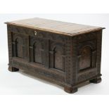 A 17th century-style carved oak coffer, with marquetry decoration to the arched panels, the hinged