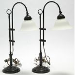 A pair of Edwardian-style table lamps with flared opaque glass circular shades on bronzed-metal