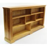A pine standing open bookcase with eight divisions, & on shaped plinth base, 76" long x 40" high.
