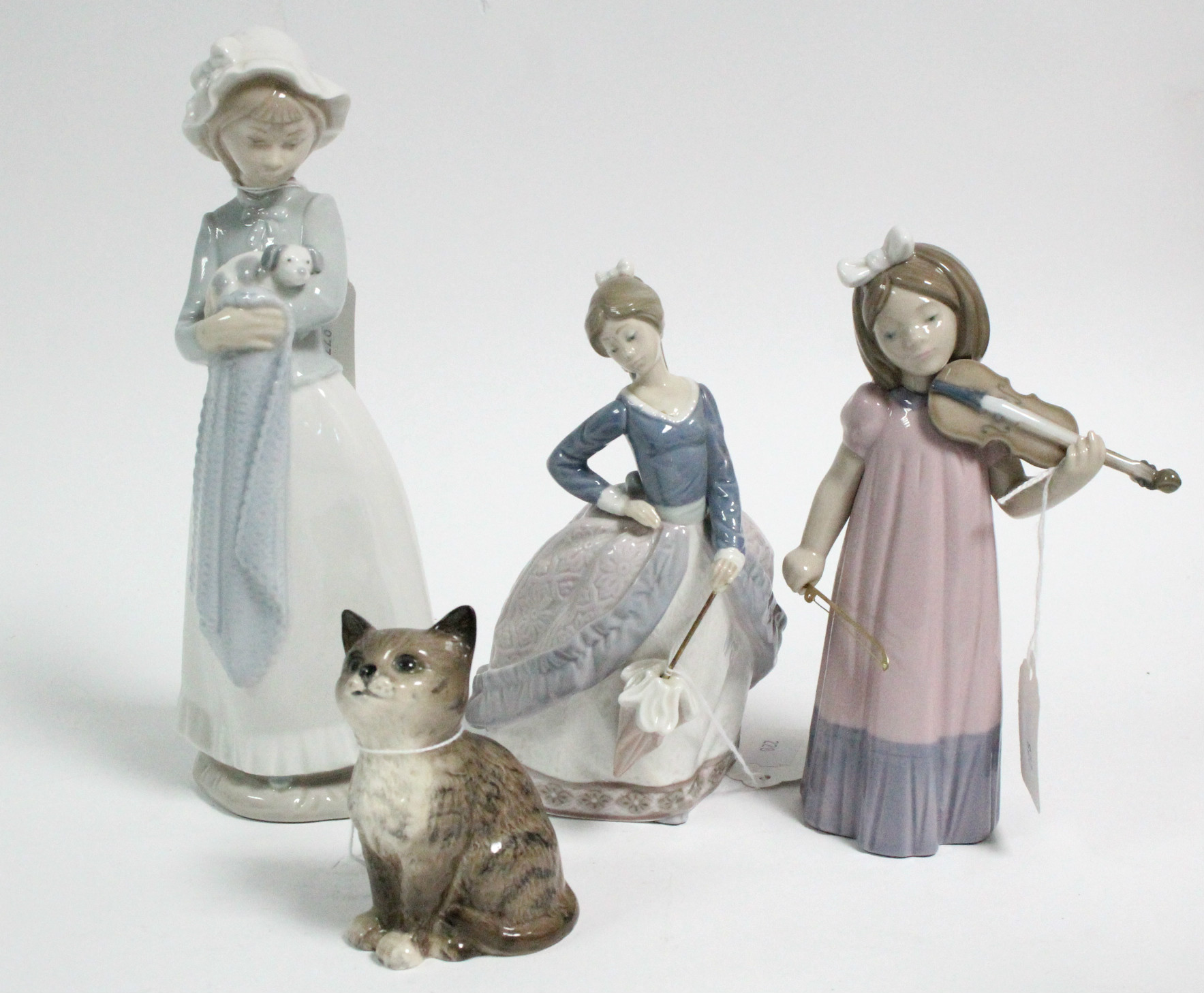 A Beswick kitten ornament; & three Lladro female figures.