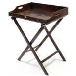 A 19th century mahogany rectangular two-handled butler's tray, 27" wide on folding stand.