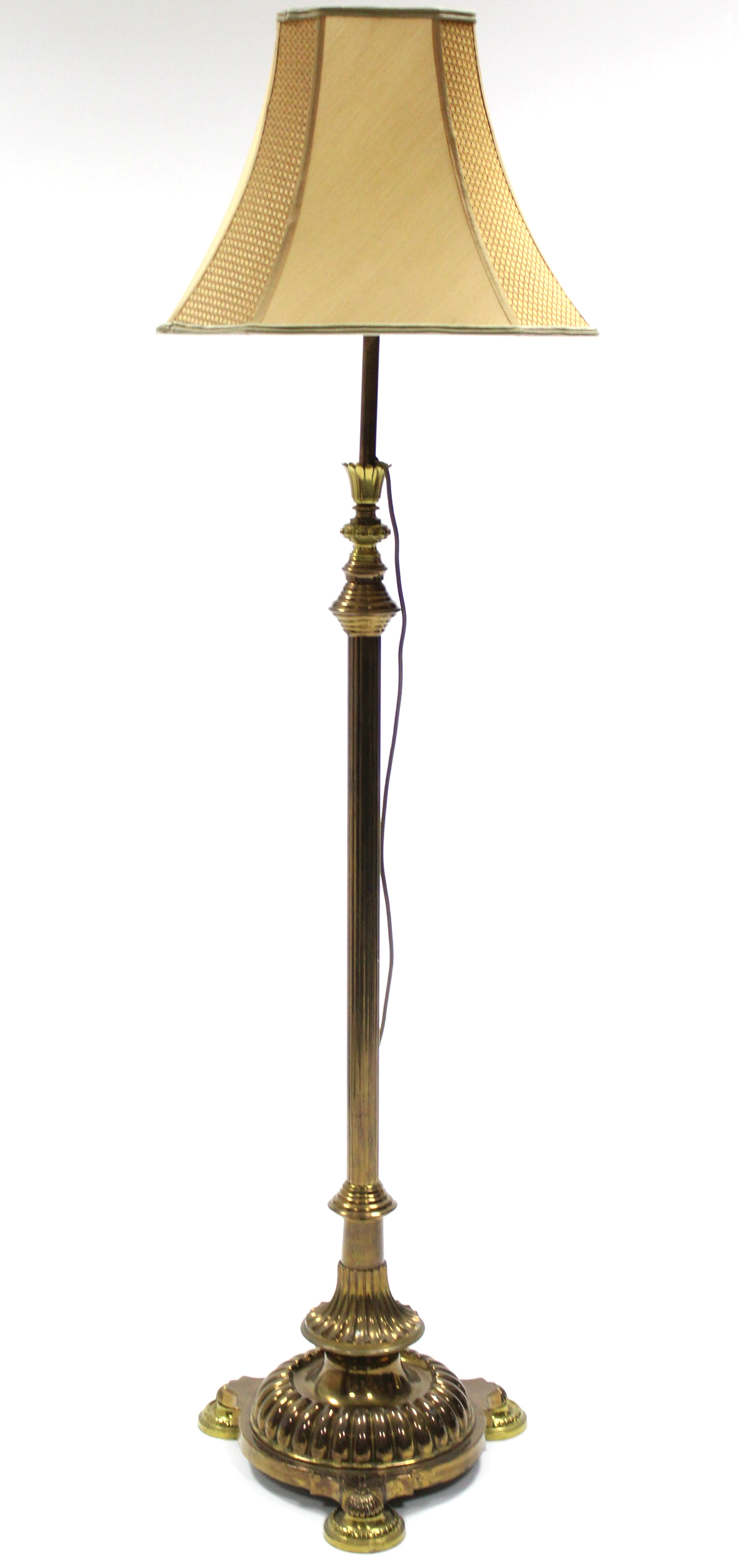 A mid-20th century brass standard lamp with reeded centre column on a fluted circular base with