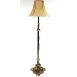 A mid-20th century brass standard lamp with reeded centre column on a fluted circular base with