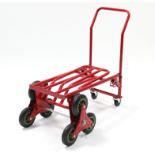 A pair of red-finish tubular-metal sack trucks; & an aluminium folding stepladder.