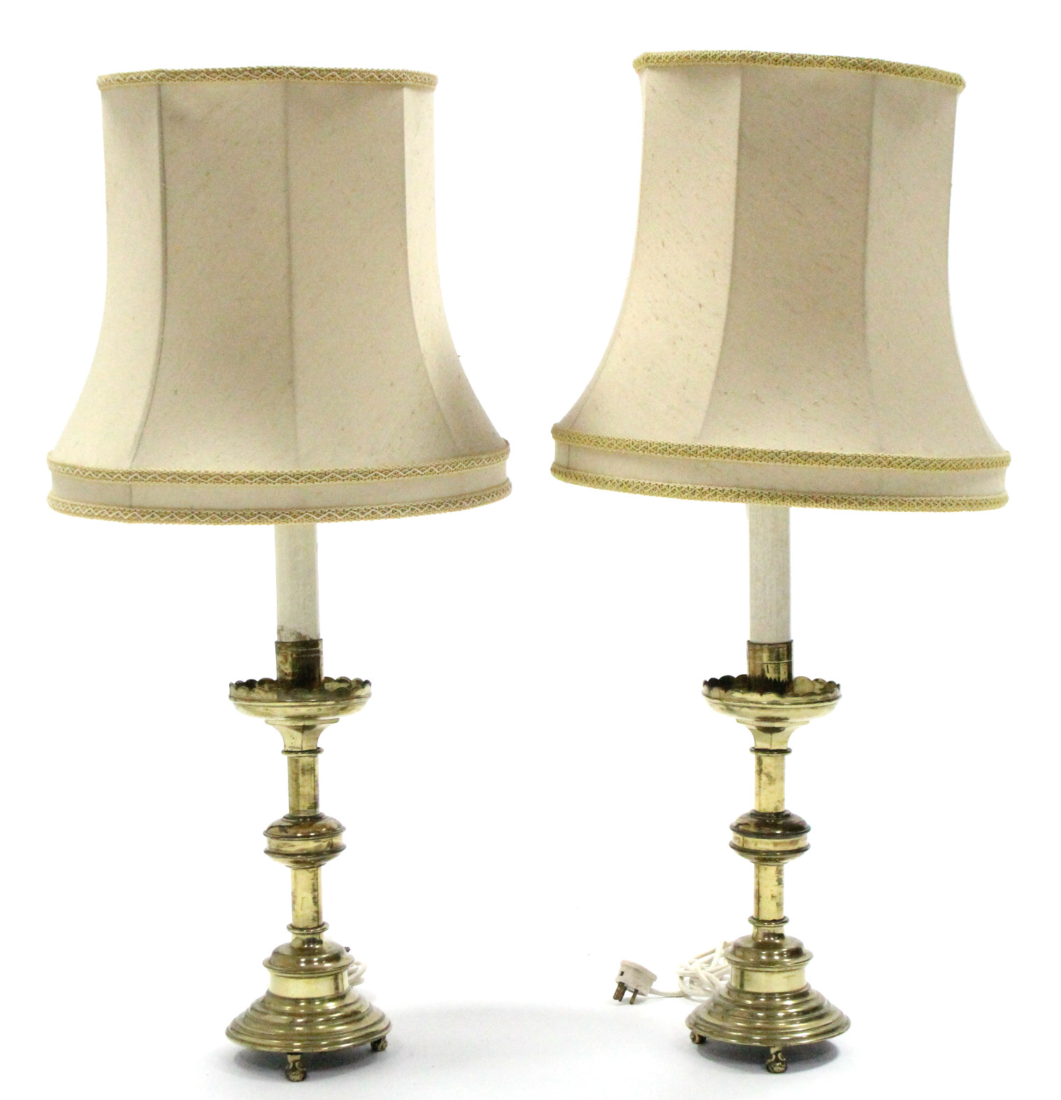 A pair of brass candle stands with lobed drip-pans, on round columns & circular bases with short