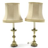 A pair of brass candle stands with lobed drip-pans, on round columns & circular bases with short