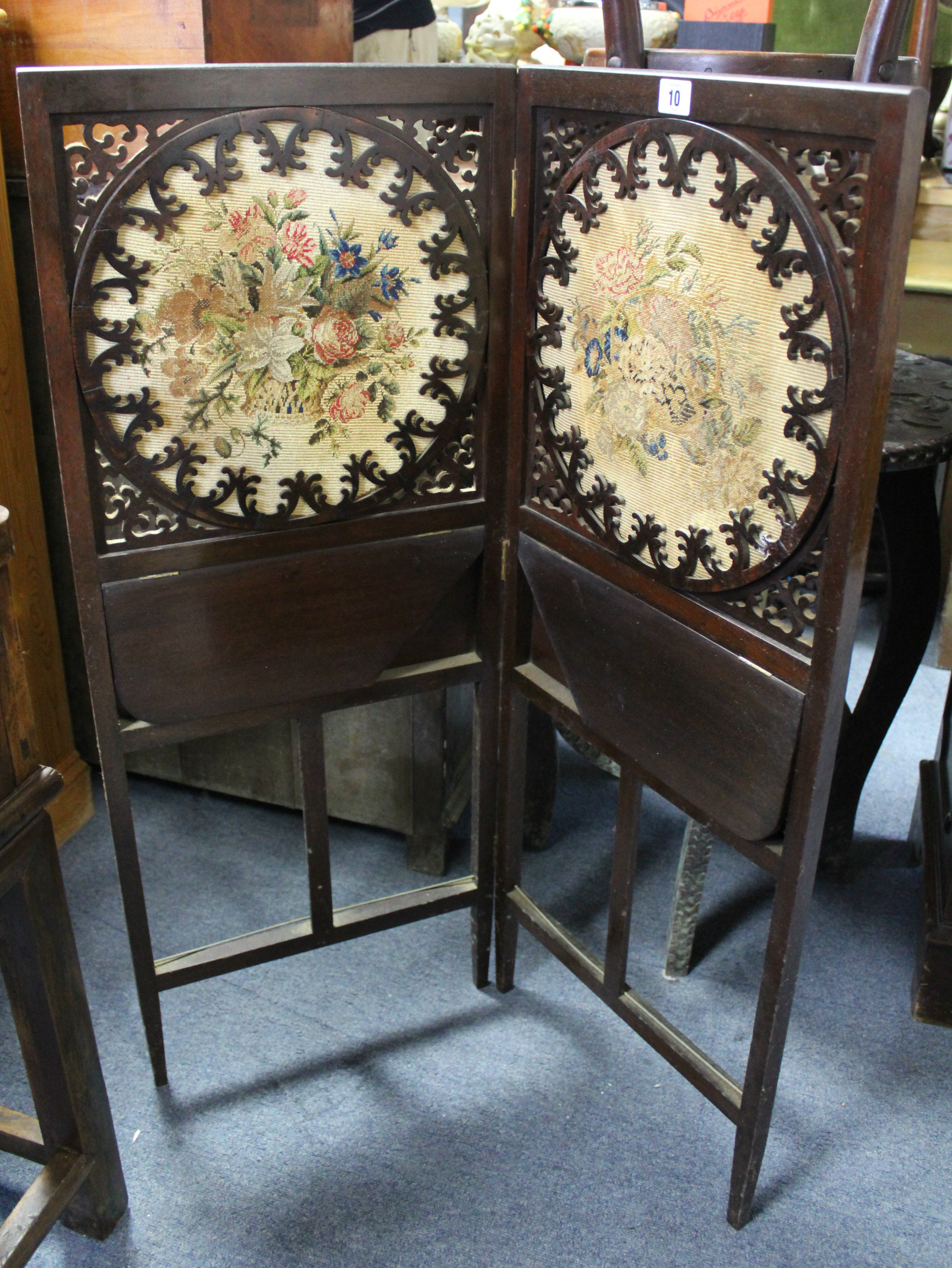 An Edwardian mahogany two-fold dwarf firescreen inset pair of embroidered floral panels above two