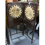 An Edwardian mahogany two-fold dwarf firescreen inset pair of embroidered floral panels above two