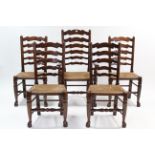 A set of five reproduction oak ladder-back dining chairs (including one carver), with woven rush