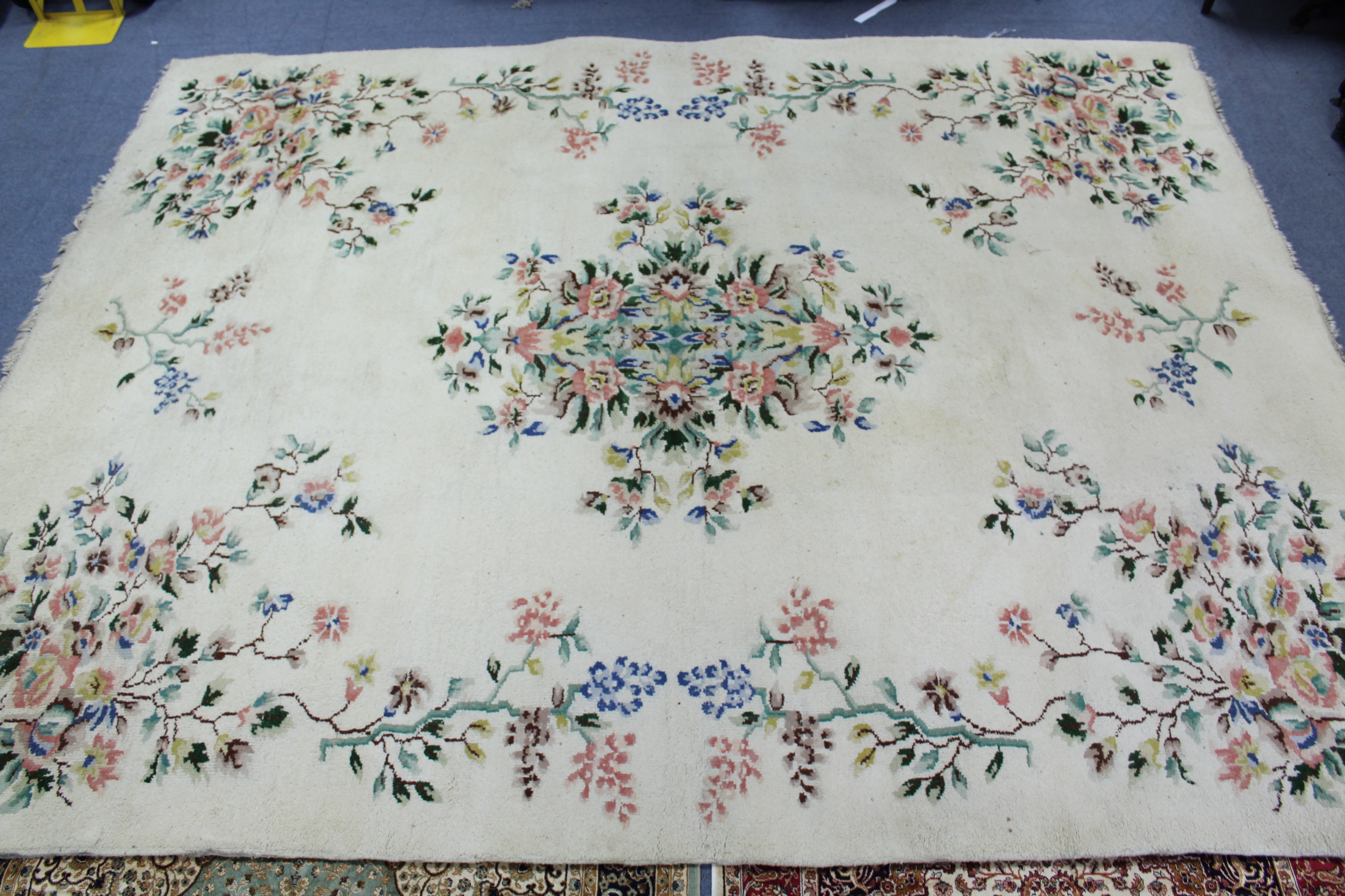 An Indian carpet of off-white ground & with all-over multicoloured floral design, 9' 7" x 12'.