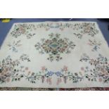 An Indian carpet of off-white ground & with all-over multicoloured floral design, 9' 7" x 12'.