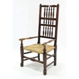 An early 19th century ash spindle-back elbow chair with woven rush seat, & on turned legs with