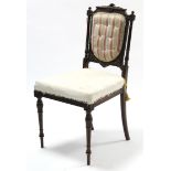 A Victorian carved mahogany occasional chair with buttoned back, sprung seat & on fluted & turned