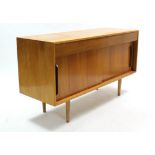 A 1960's teak sideboard fitted two frieze drawers above cupboard enclosed by pair of sliding panel