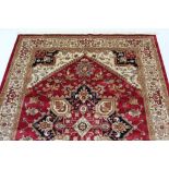 A Heriz carpet of crimson & ivory ground, with geometric design to centre within a wide border, 110”