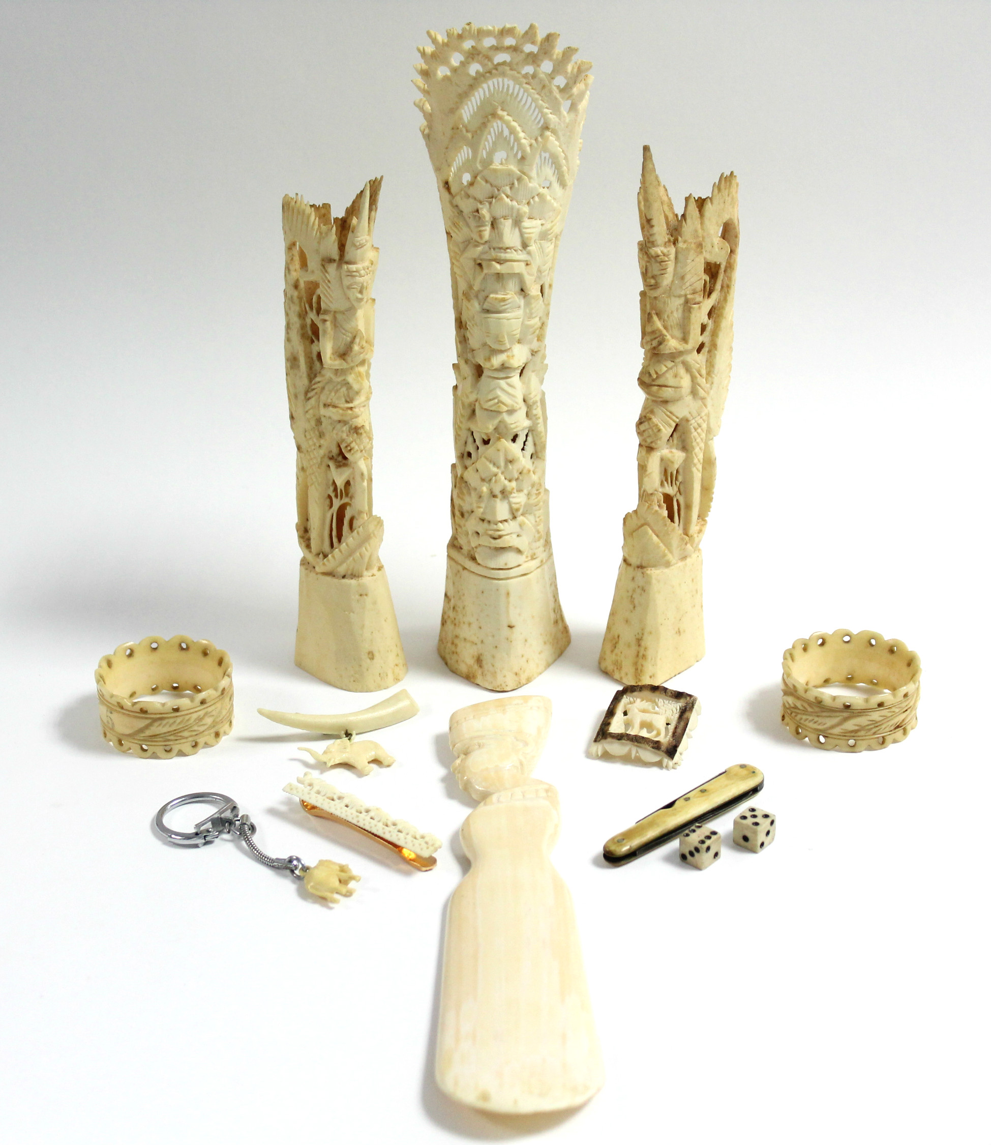 An ivory shoehorn with bust handle; a pair of carved ivory napkin rings; three ivory brooches; &