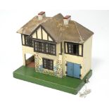 A 1930’s Tri-ang painted wooden two-storey doll’s house with opening front, & with electric