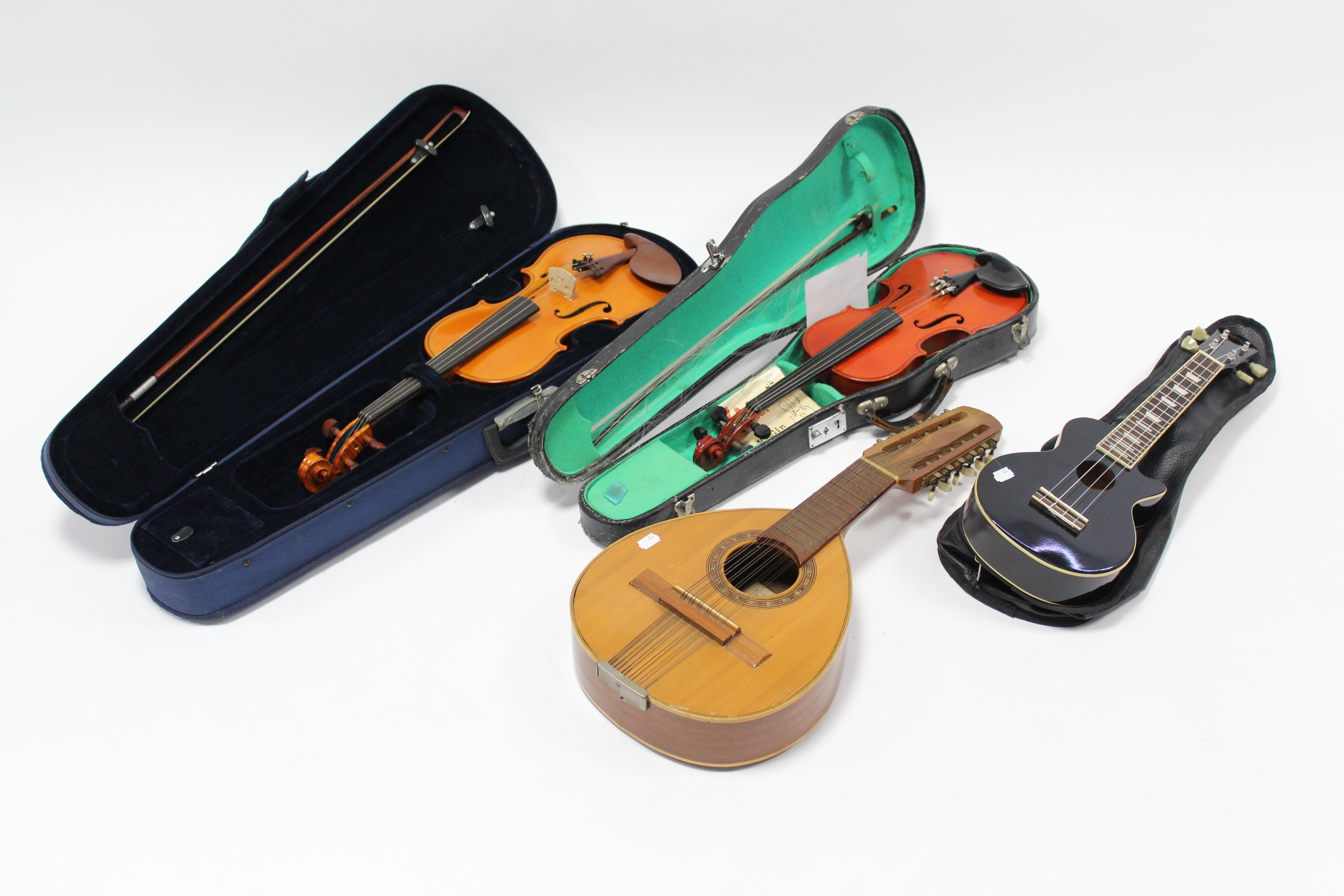 A modern violin; a modern child’s violin; & two stringed instruments.