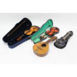 A modern violin; a modern child’s violin; & two stringed instruments.