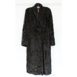 A rabbit fur silk-lined ladies’ three-quarter length coat; together with a fibre-covered suitcase; &