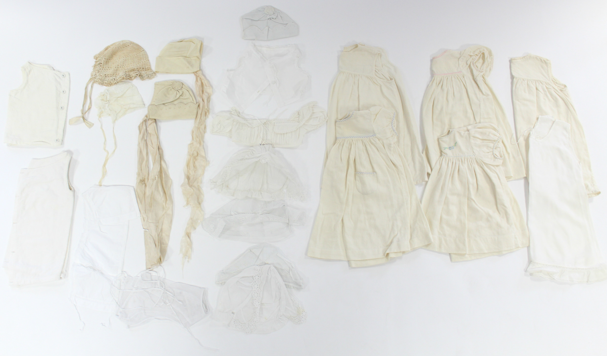 Five early 20th century cream flannel wrappers; two hand-knitted cream wool shawls; five circa