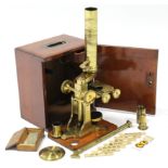 A late 19th century brass monocular microscope by Carey of London, 13½” high, in fitted mahogany