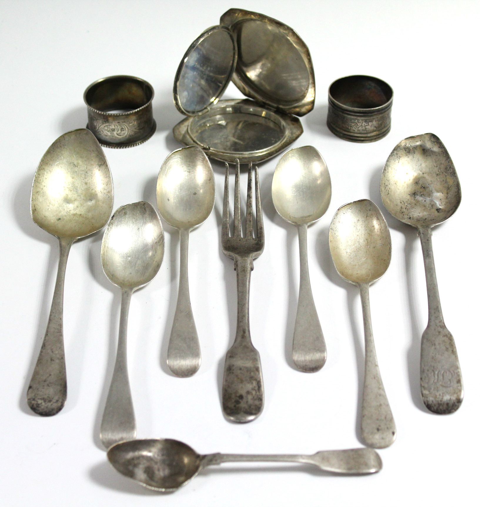 A Sterling silver engraved compact; two silver napkin rings; seven various silver spoons; & a silver
