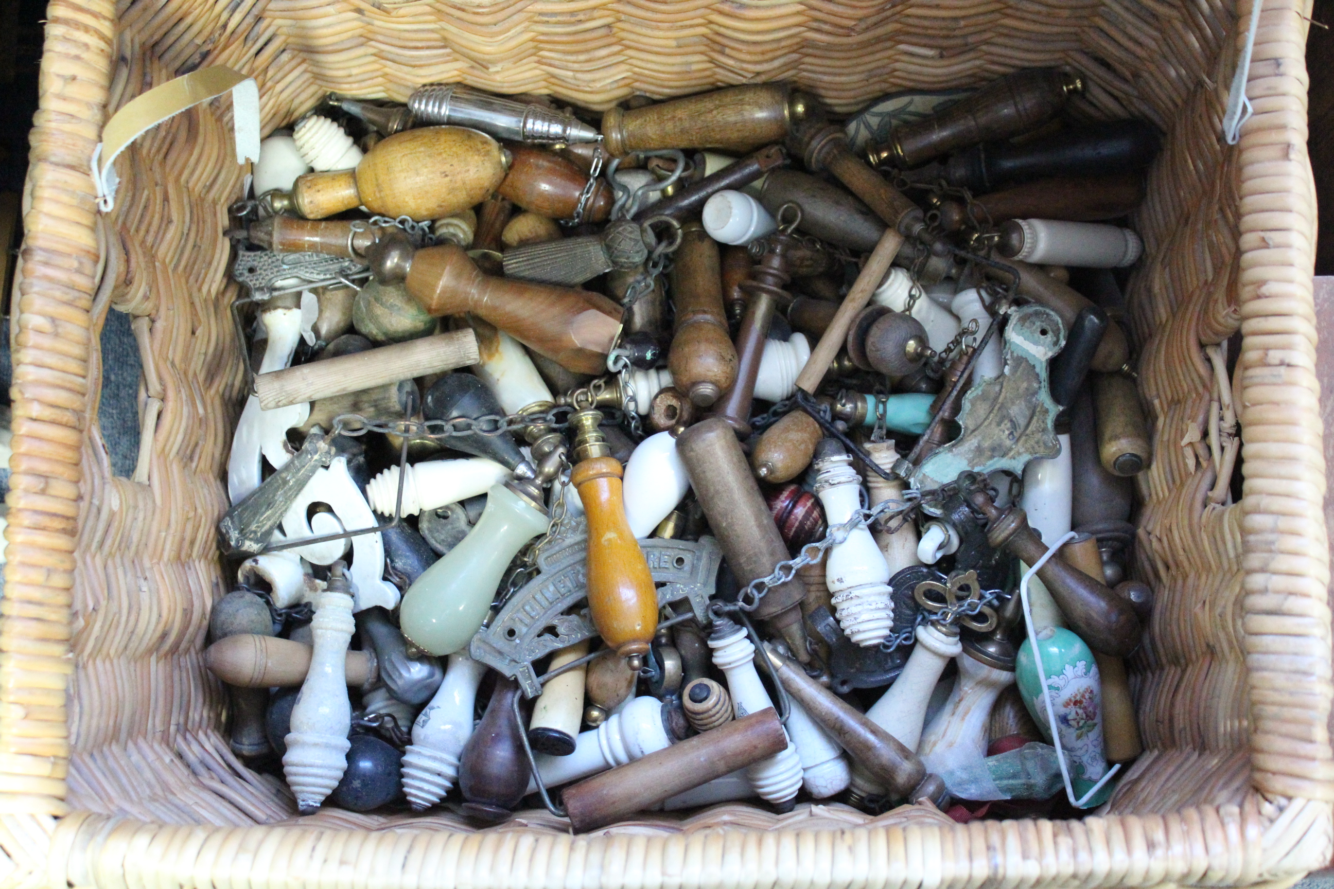 A Collection of approximately one hundred various pull chain handles; & a wicker basket.