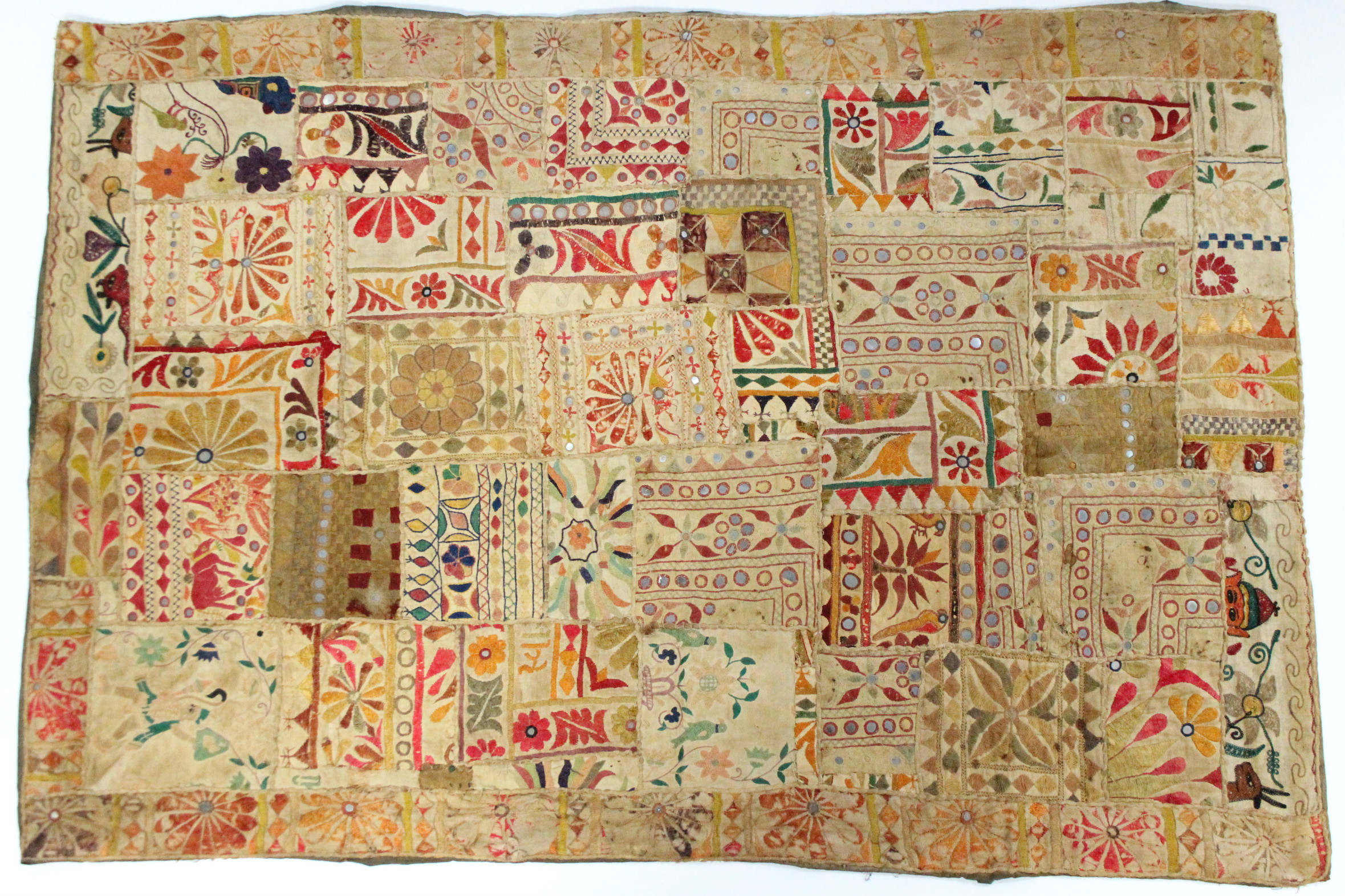An Indian embroidered patchwork panel with multi-coloured designs of stylised flowers & animals;