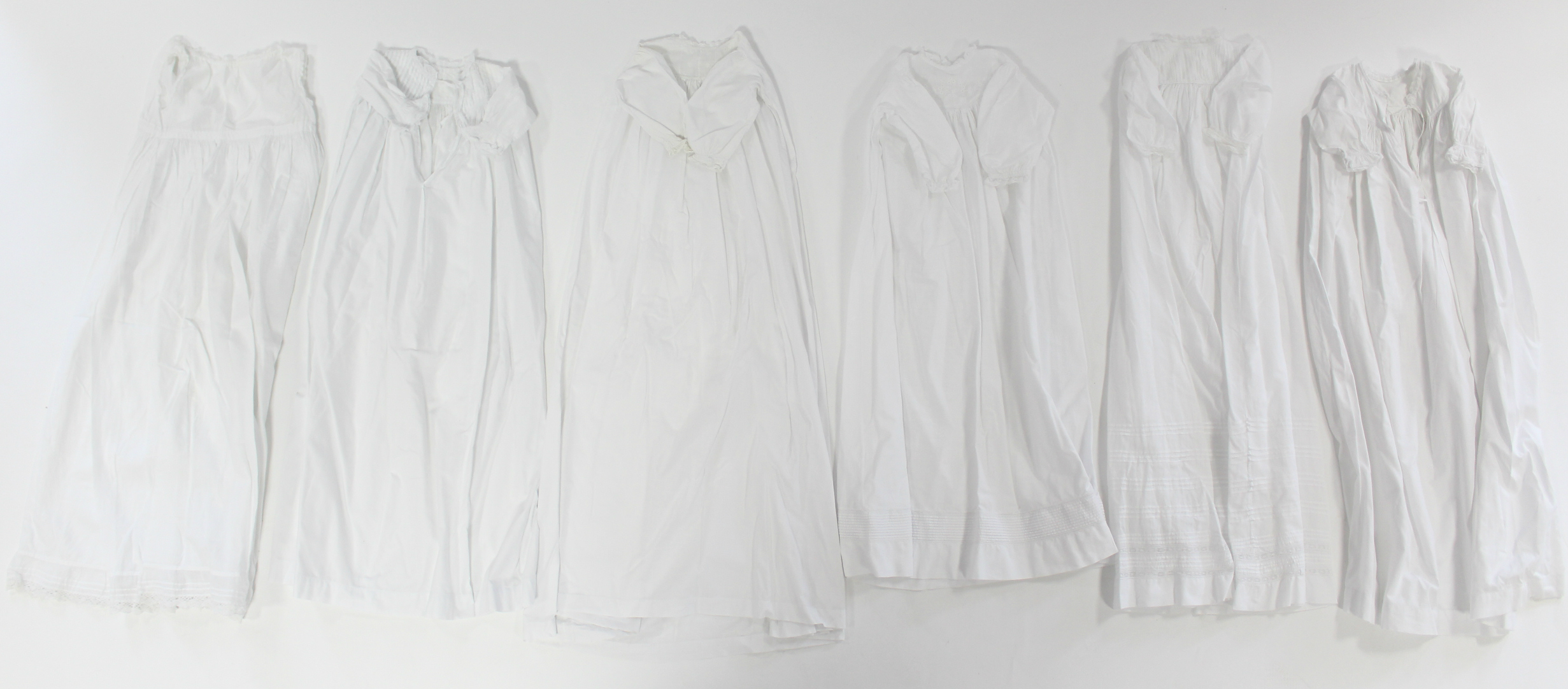 Twelve various early 20th century babies’ embroidered white cotton long gowns.