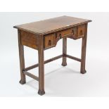 An early 20th century oak kneehole writing table, inset gilt-tooled brown leather cloth, fitted