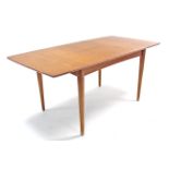 A teak rectangular extending dining table with centre leaf, & on round tapered legs, 33” x 66” (