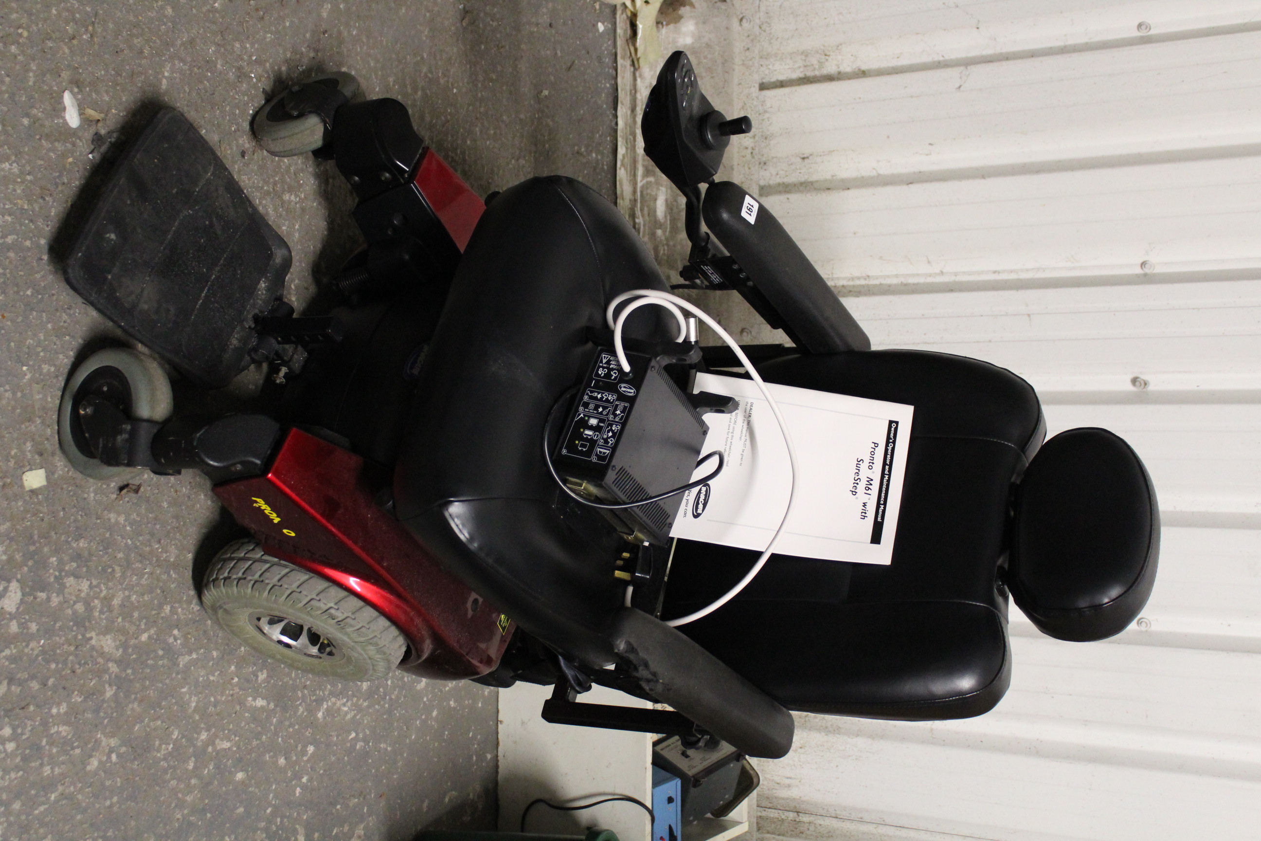 An Invacare “Pronto M61” electrically-operated wheelchair, with charger, w.o.