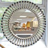 An R.V. Astley large circular wall mirror with bevelled plate, & with silver & black-finish