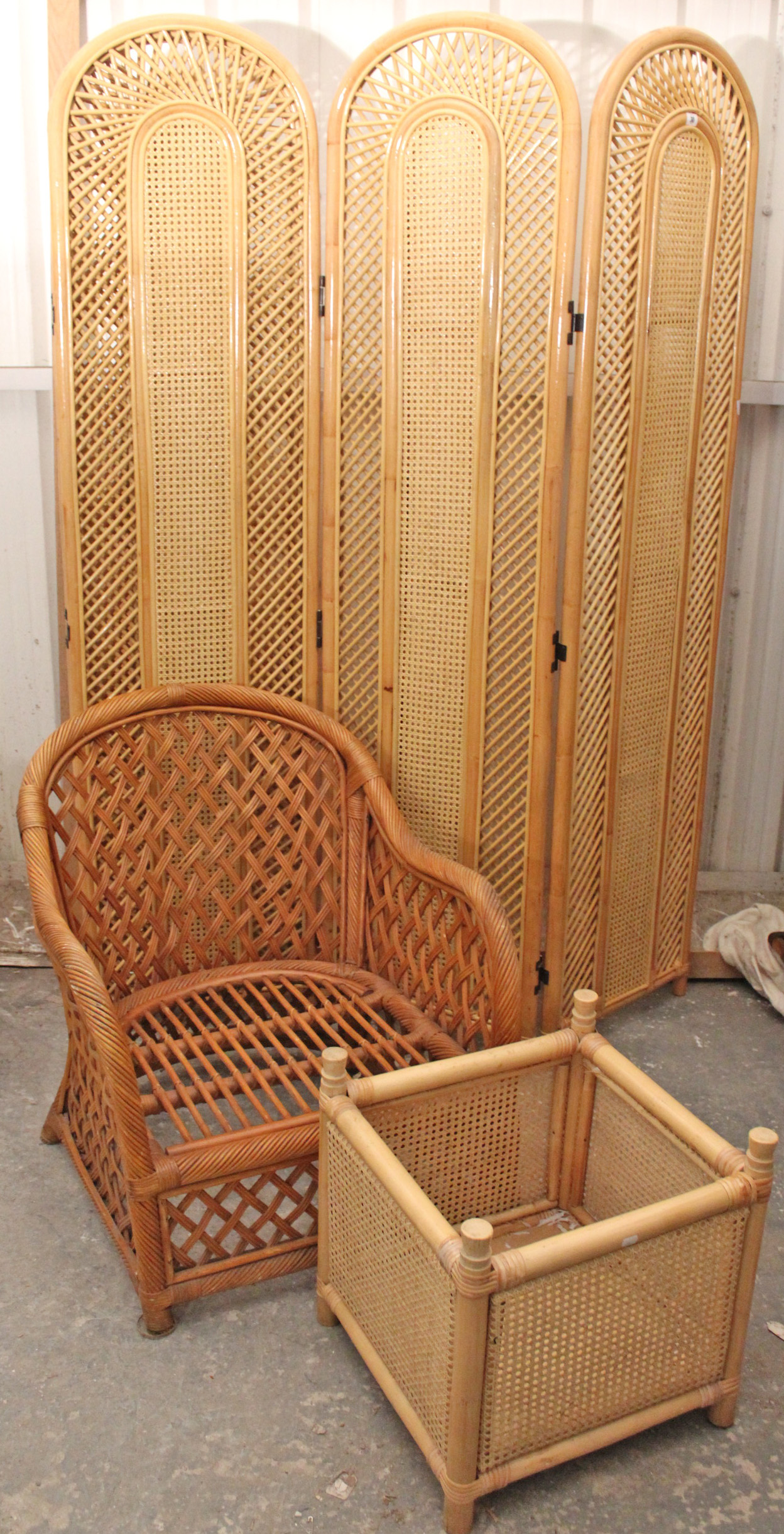 A rattan tall four-fold draught screen inset woven cane panels, 81” high; a rattan armchair with