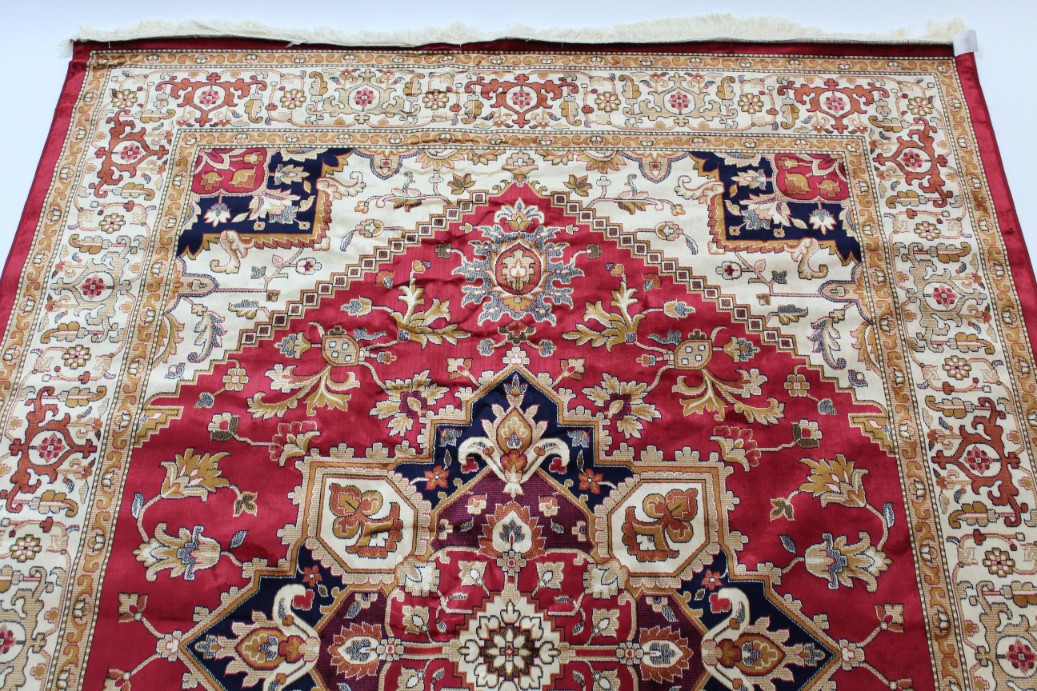 A Heriz carpet of crimson & ivory ground, with geometric design to centre within a wide border, 110” - Image 2 of 2