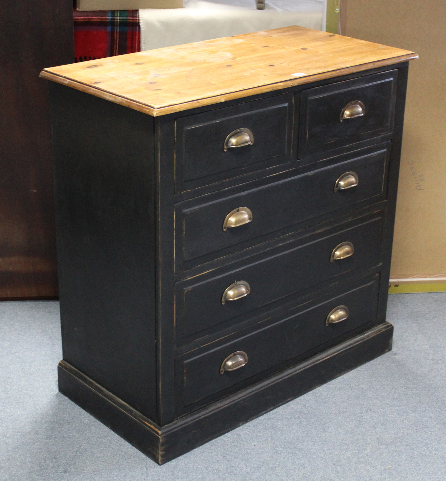 A natural & black painted pine chest fitted two short & three long drawers with brass cup handles, &