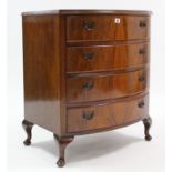 A reproduction walnut small bow-front chest fitted four long drawers with brass swing handles, &