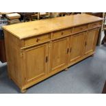 A Victorian-style pine dresser base, fitted four frieze drawers above cupboard enclosed by two pairs