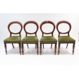 A set of four Victorian mahogany balloon-back dining chairs with padded seats, & on turned tapered