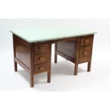 A painted & plain wooden kneehole office desk, fitted with an arrangement of five drawers, & on