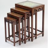 A Chinese hardwood nest of four rectangular occasional tables, each table with carved & pierced
