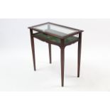 An Edwardian mahogany bijouterie table, enclosed by bevelled glazed hinged lift-lid, with glazed