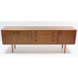 An Avalon teak sideboard, fitted with an arrangement of cupboards & drawers, & on short square