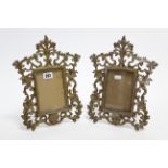 A pair of cast & gilt brass rectangular photograph frames on easel supports, 12” x 9”; & an Art-