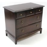 A stag “Minstrel” mahogany-finish small chest fitted three short & two long drawers, & on shaped