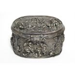 A continental white metal oval box, decorated in relief with scenes of huntsmen, figures & animals